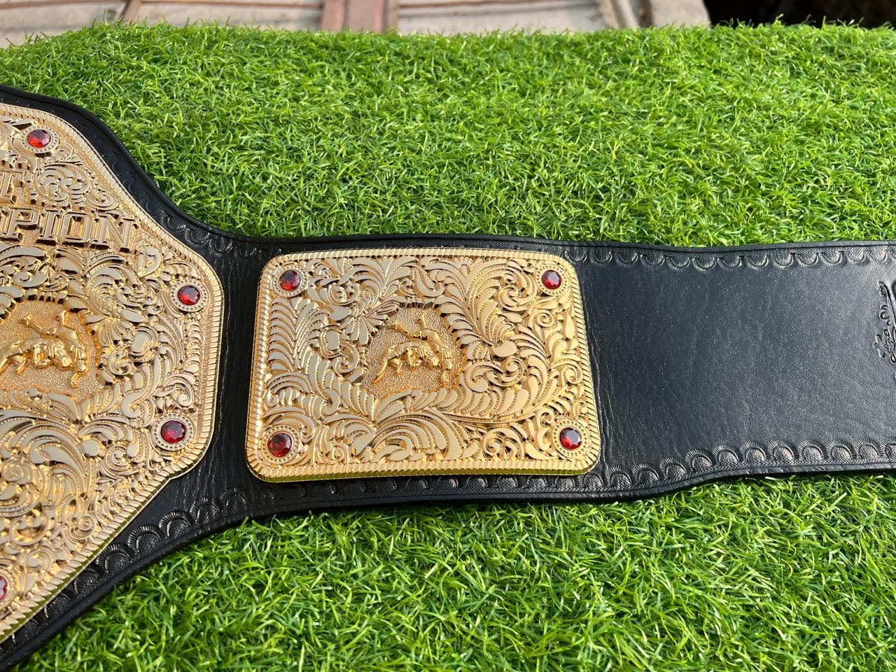 Big Gold Deep-Engraved Heavyweight Belt laid flat, showing the centre plate and side plates on a black leather strap
