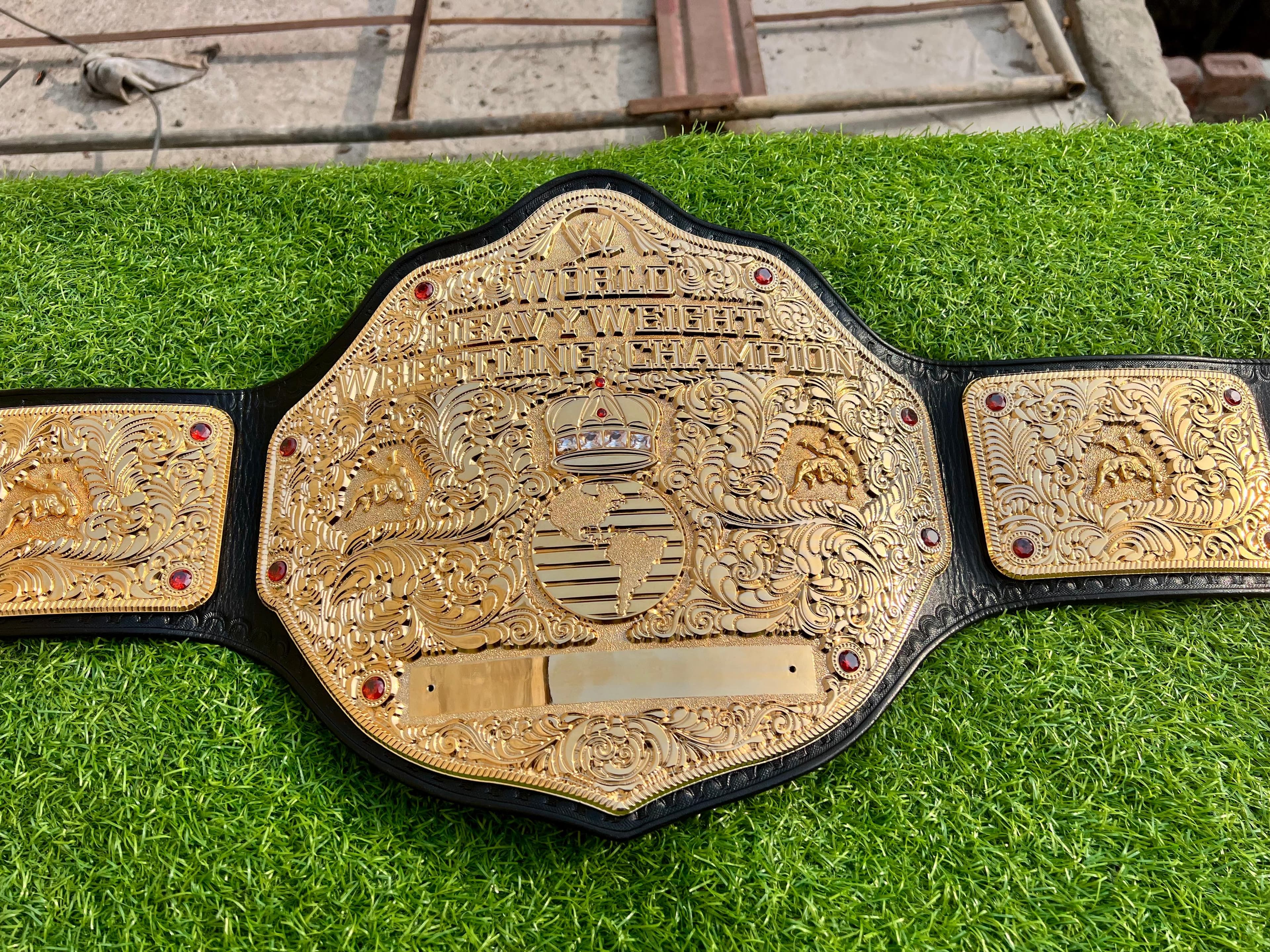 Big Gold Platinum Heavyweight Championship Belt laid flat, showing the centre plate and side plates on a black leather strap