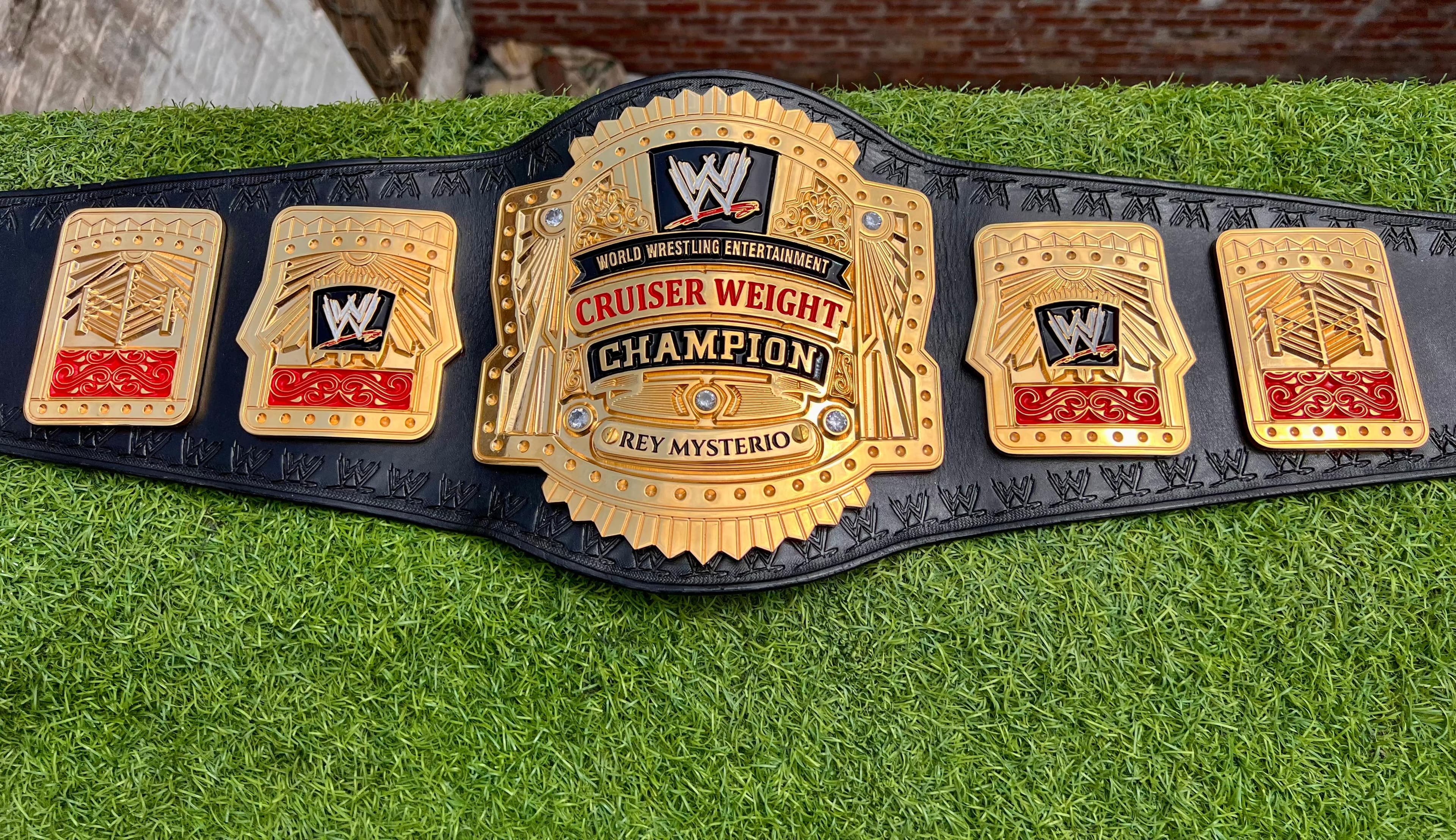 Cruiserweight Champion Style Belt laid flat, showing the centre plate and side plates on a black leather strap