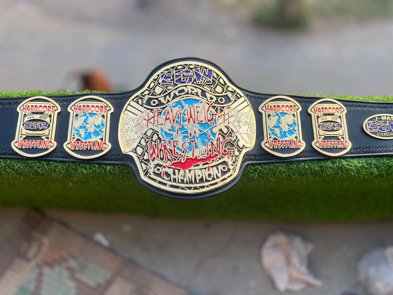Hardcore World Heavyweight Championship Belt laid flat, showing the centre plate and side plates on a black leather strap