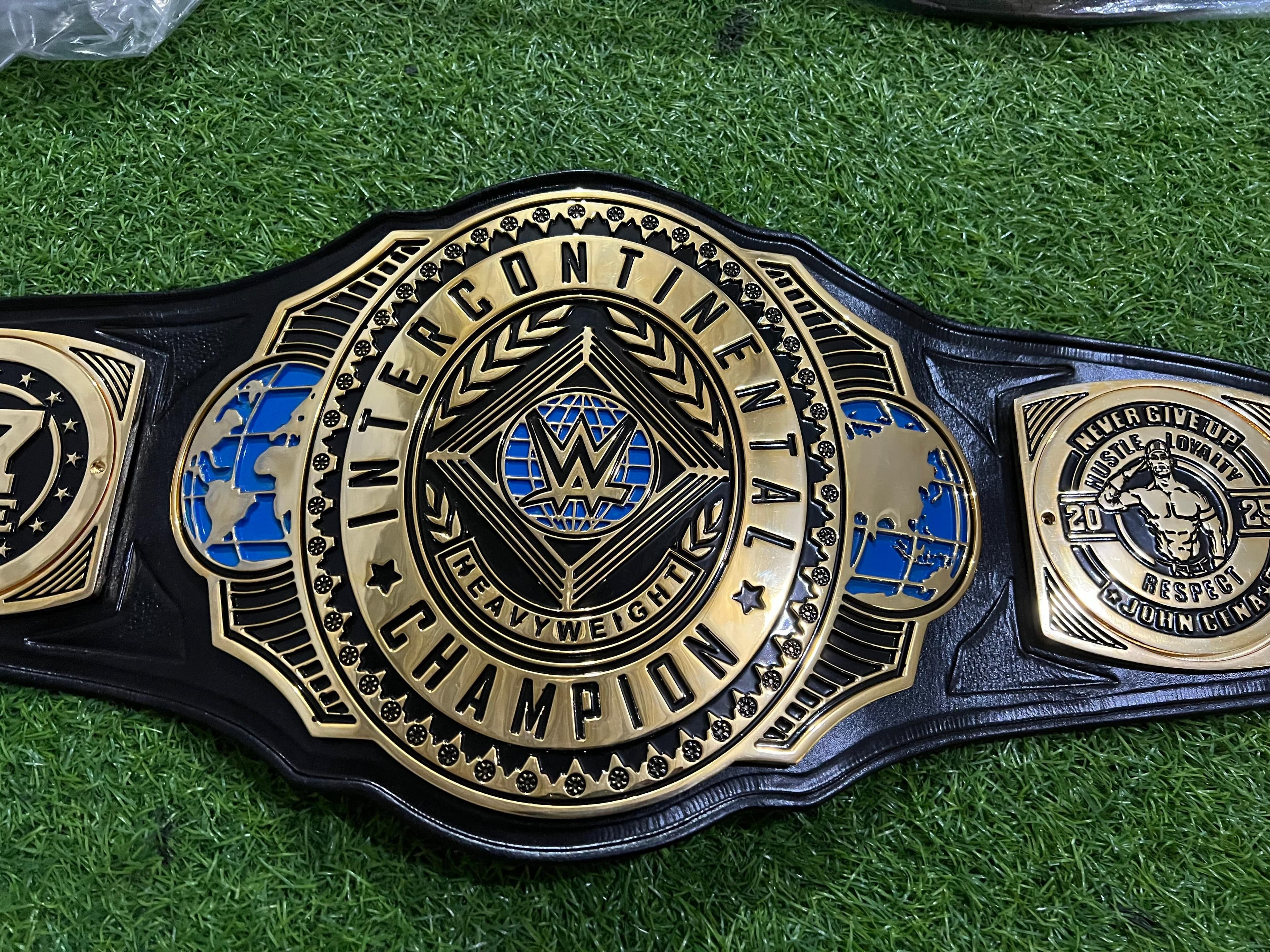 Modern Continental Heavyweight Championship Belt laid flat, showing the centre plate and side plates on a black leather strap