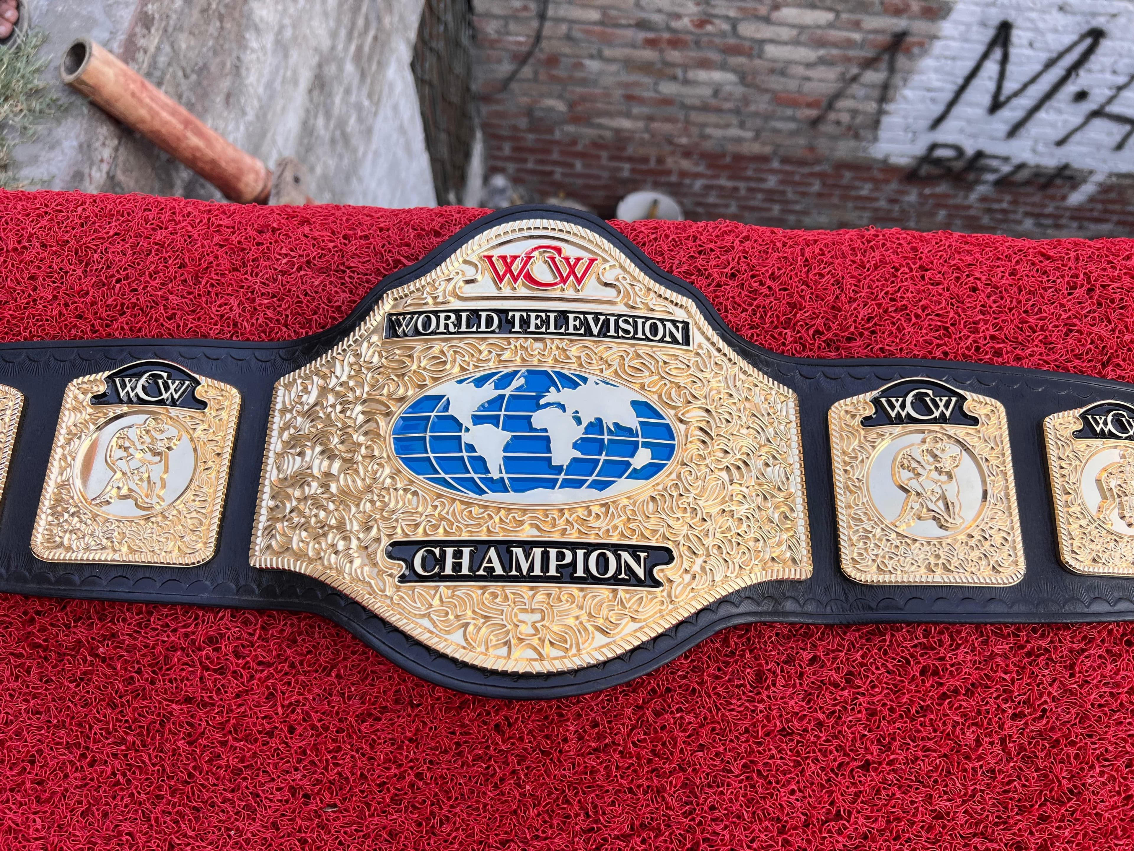 World Television Gold Championship Belt laid flat, showing the centre plate and side plates on a black leather strap